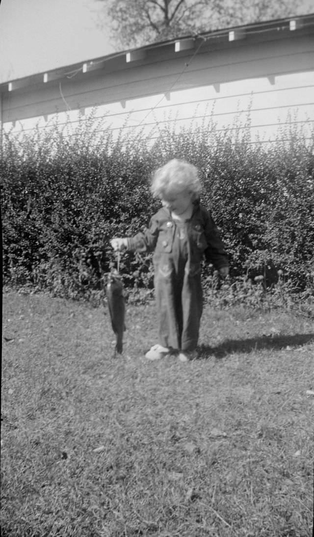 Child holding a fish outside
