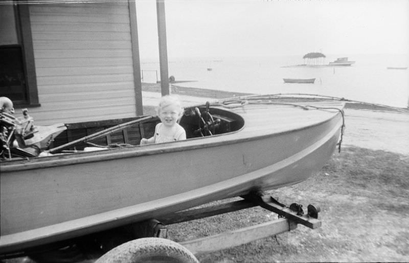 Smiling girl sitting in a boat on a trailer