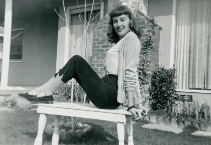 Teenage girl posing on table outside