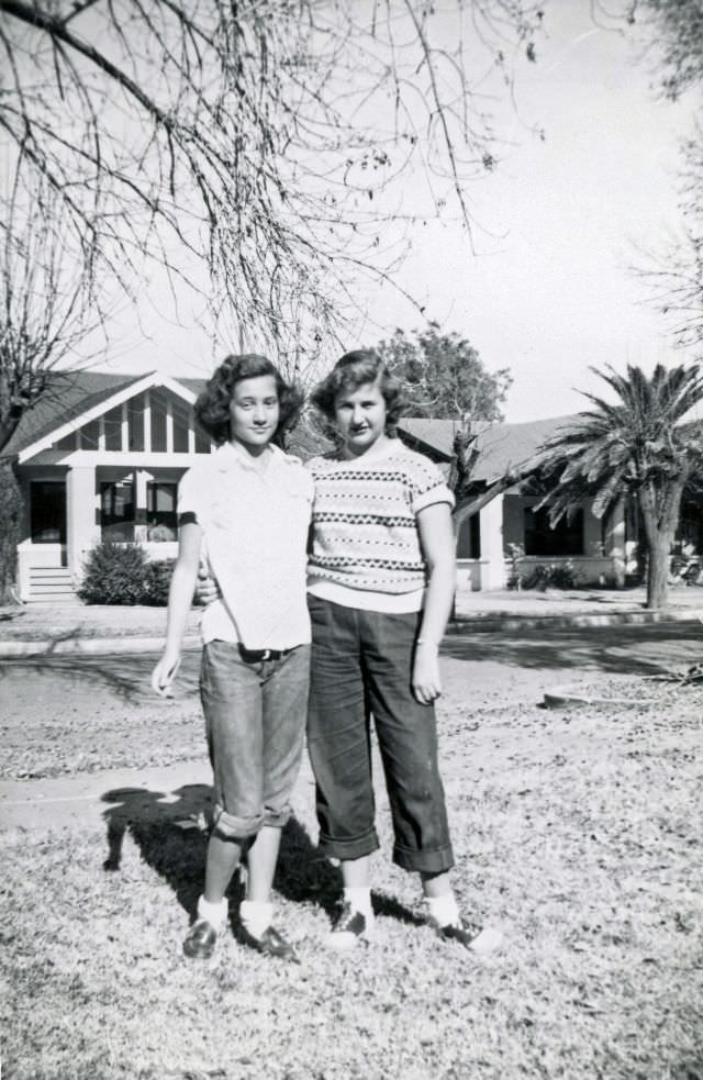 Two teen girls pose on lawn