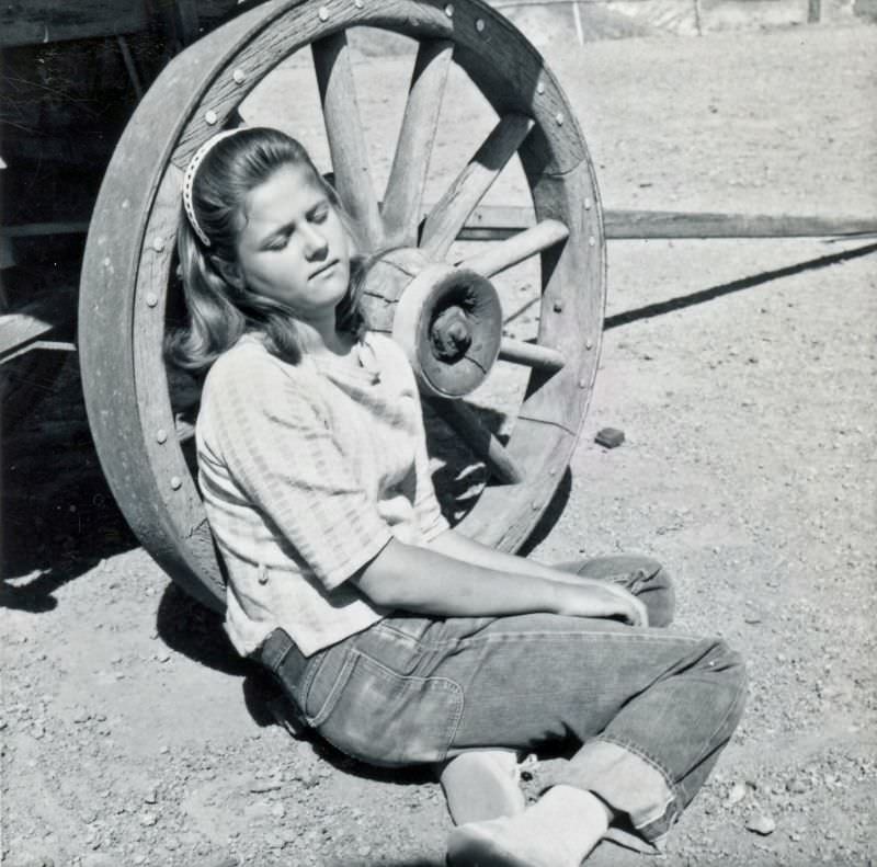 Girl by wagon wheel