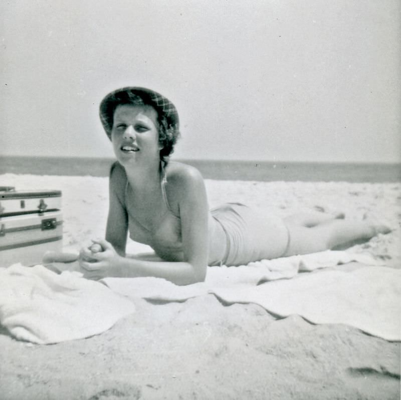 Girl in swimsuit and hat posing on beach