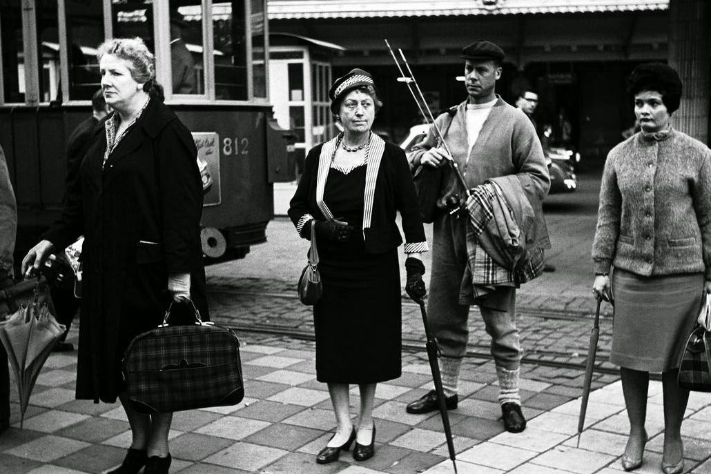 People wait for a tram outside of Centraal Station, 1964