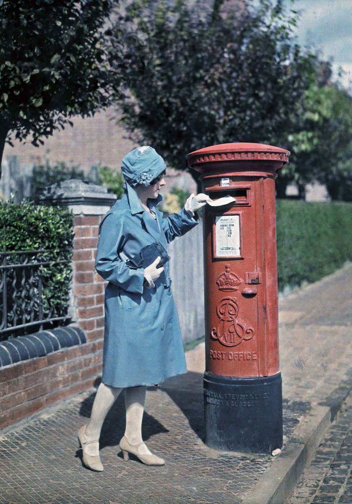 A young woman mails a letter at the pillar box, in Oxford.