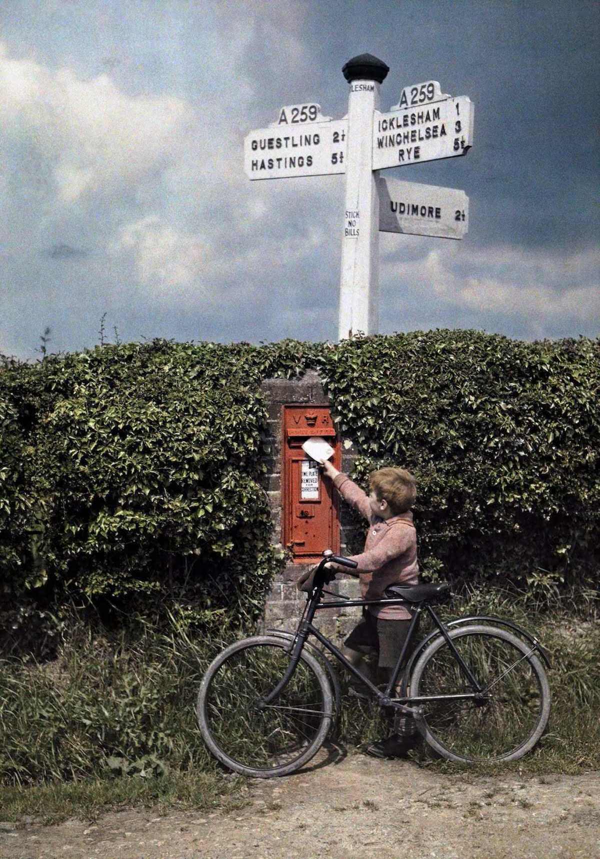 A little boy mails a letter in the hedgerow, in Sussex.