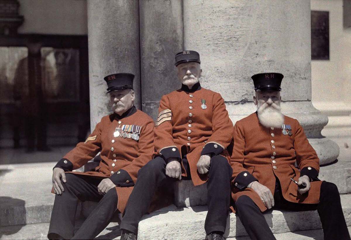 Veteran soldiers – known as Chelsea Pensioners – sit on the steps of the Royal Hospital Chelsea in London.
