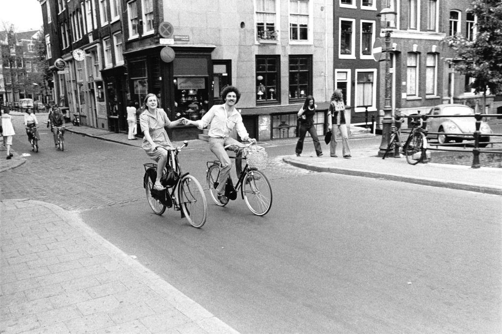 Couple of cyclists on a street in central Amsterdam, 1950s.