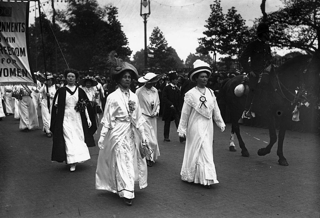 Emmeline Pankhurst leads a suffragette parade through London, with the protesters all dressed in white.