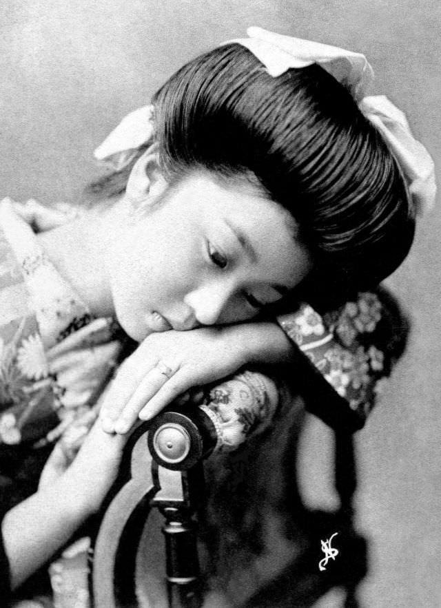 A geisha waits between poses as the photographer changes out lenses