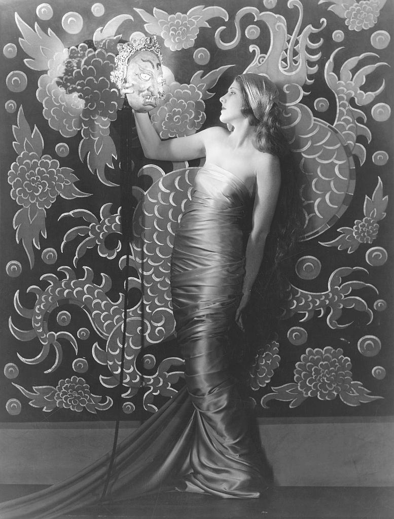 Jean Arthur holding an asian style mask, 1930.