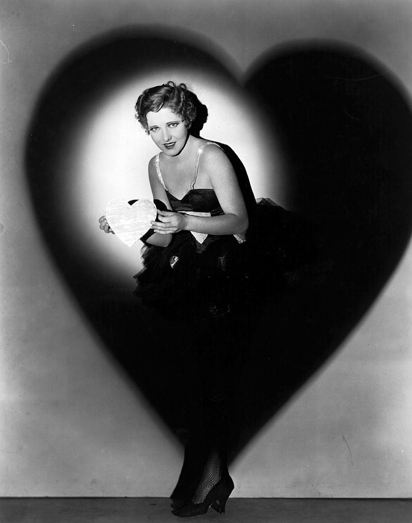 Jean Arthur in a heart shaped shadow and holds a heart shaped card, 1930.