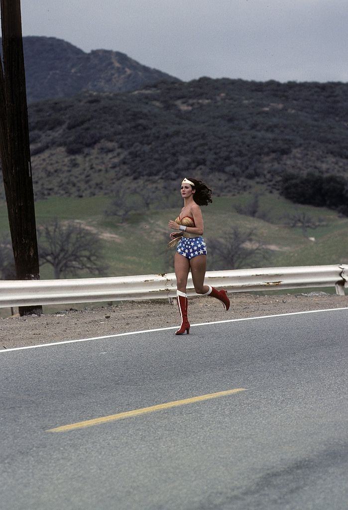 Lynda Carter chasing a vehicle in 'The New Original Wonder Woman', 1975.