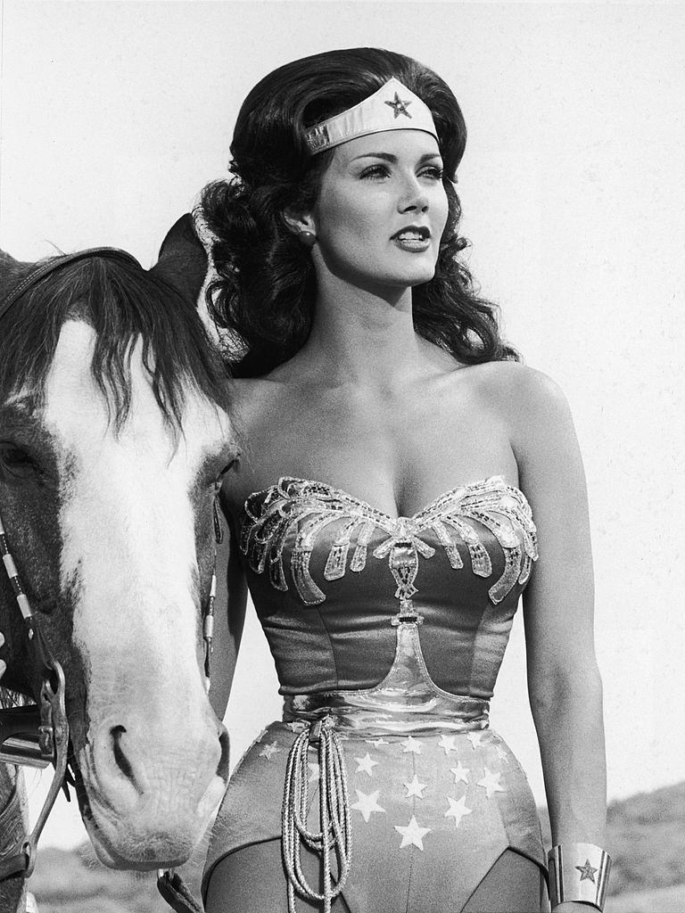 Lynda Carter stands next to a horse in a still from the television series, 'Wonder Woman,' 1978.