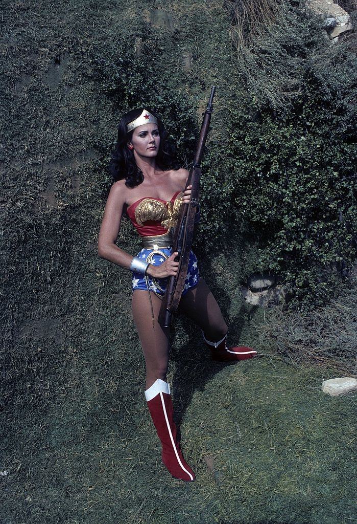 Lynda Carter holding a rifel as Wonder Woman in the episode 'The Feminum Mystique'.