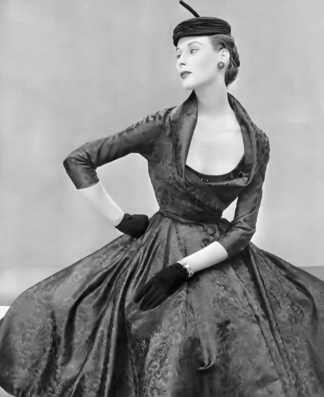 Myrtle Crawford in silk dress with embroidered bodice under fitted bolero with deep shawl collar by Nina Ricci, hat by Claude St. Cyr, 1953