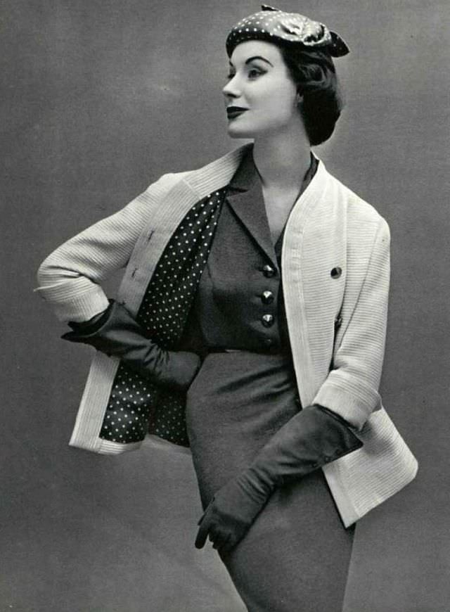 Myrtle Crawford in white ribbed wool jacket worn over gray jersey dress, jacket is lined in gray and white polka-dotted silk, 1953