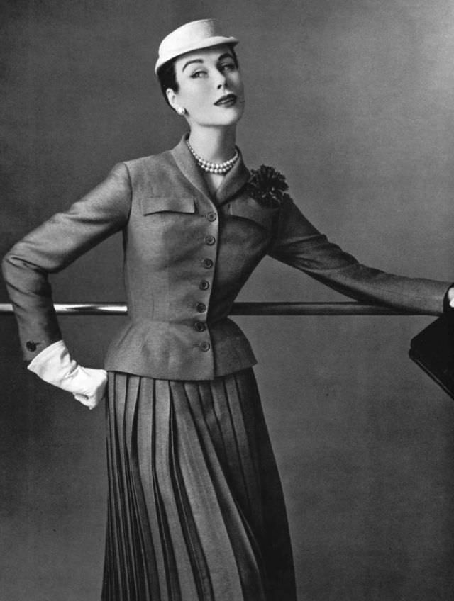 Myrtle Crawford in this short fitted jacket worn over pleated skirt by Jean Patou, 1954.