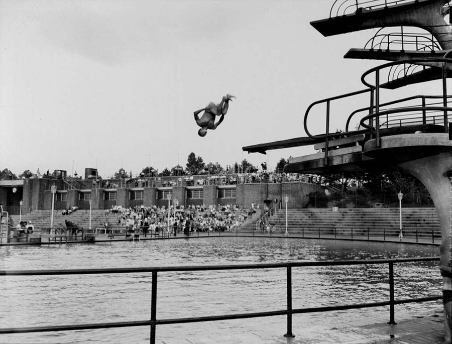 A young man is pictured above on August 17, 1943, completing an incredible dive during a competition at Astoria pool, which still exists today.