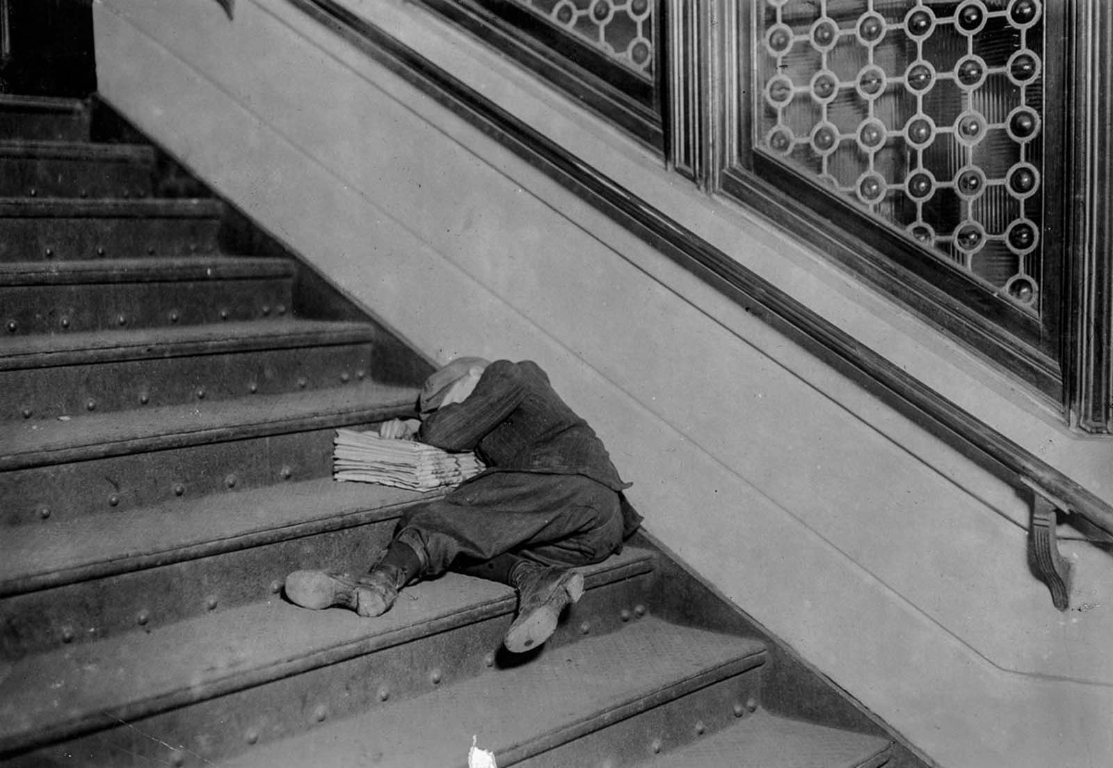 Newsboy asleep on stairs with papers. Jersey City, New Jersey.” 1912.