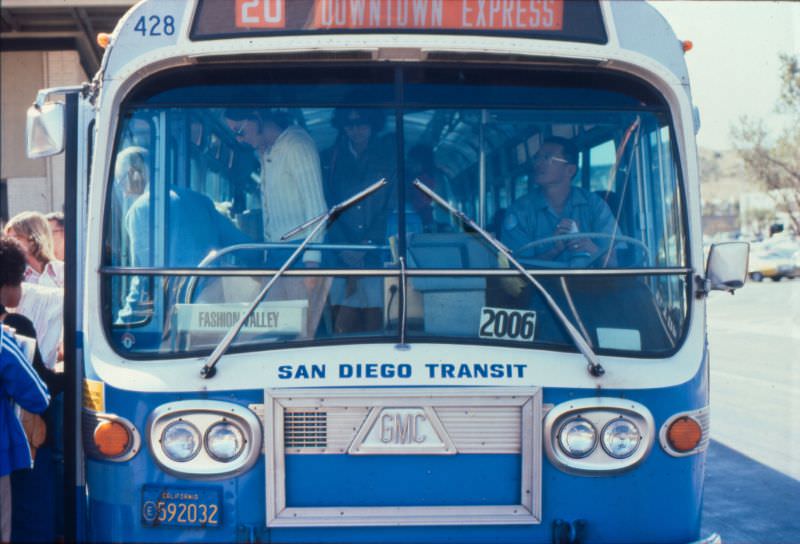 A 1972 GMC bus operating on Route 20 drops off passengers at the Fashion Valley Transit Center