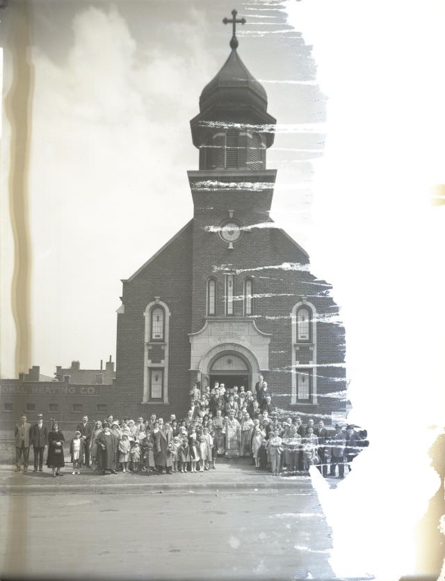 Large group posed around three members of the clergy on the steps of the Holy Trinity Serbian Eastern Orthodox Church at the corner of Geyer and McNair, April 1931