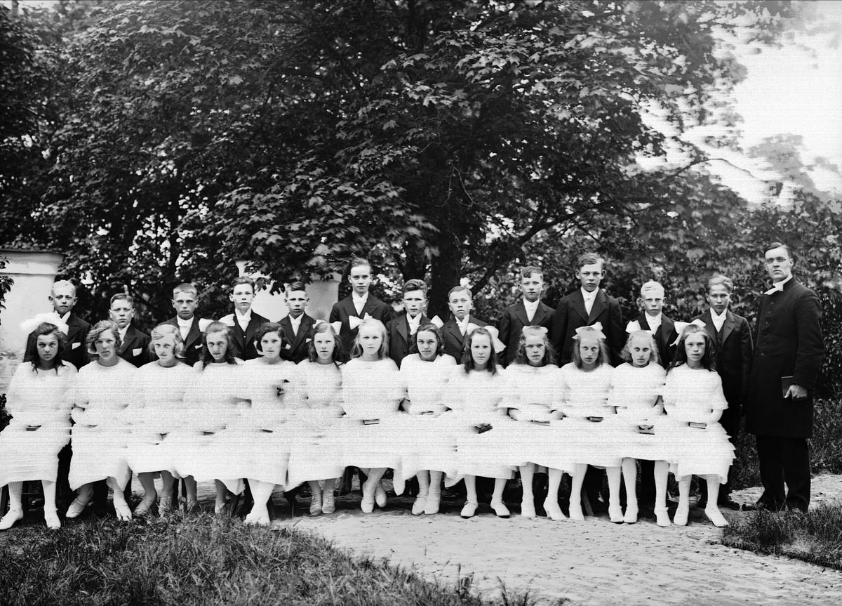 Pastor Magnusson with confirmands outside Altuna church, Uppland 1925