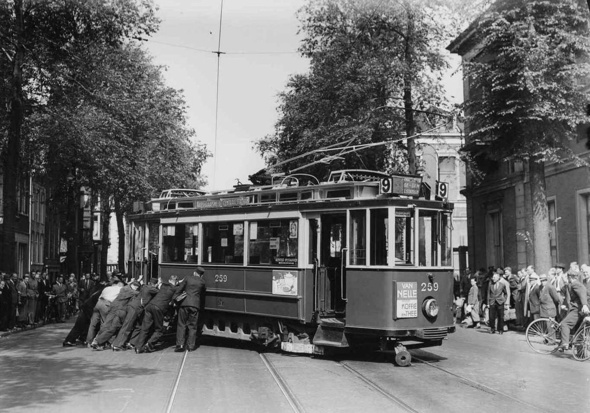 Tram 9 is placed on the rails with united force after a collision with a municipal garbage truck on the Plantage Middenlaan, June 25, 1948.