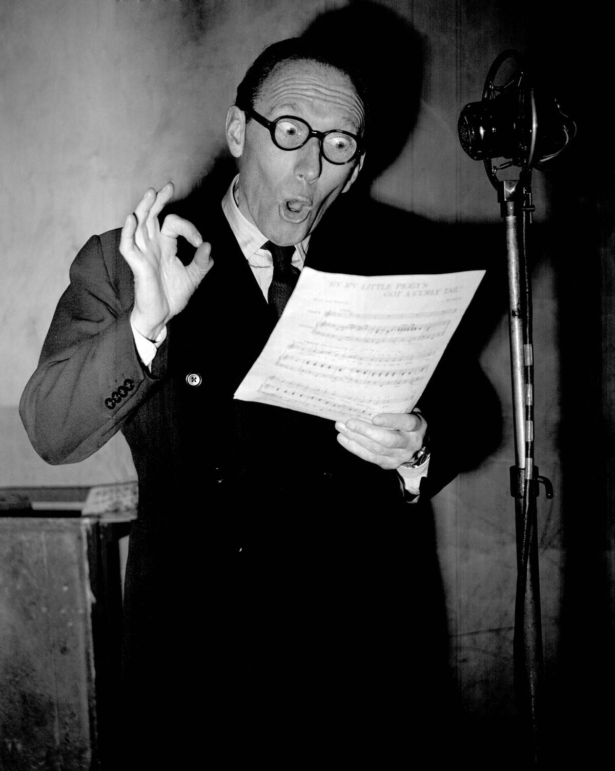 The popular radio and stage comedian Arthur Askey at the microphone to sing ‘Ev’ry Piggy’s Got a Curly Tail’ at the EMI Studios in Abbey Road, north west London.