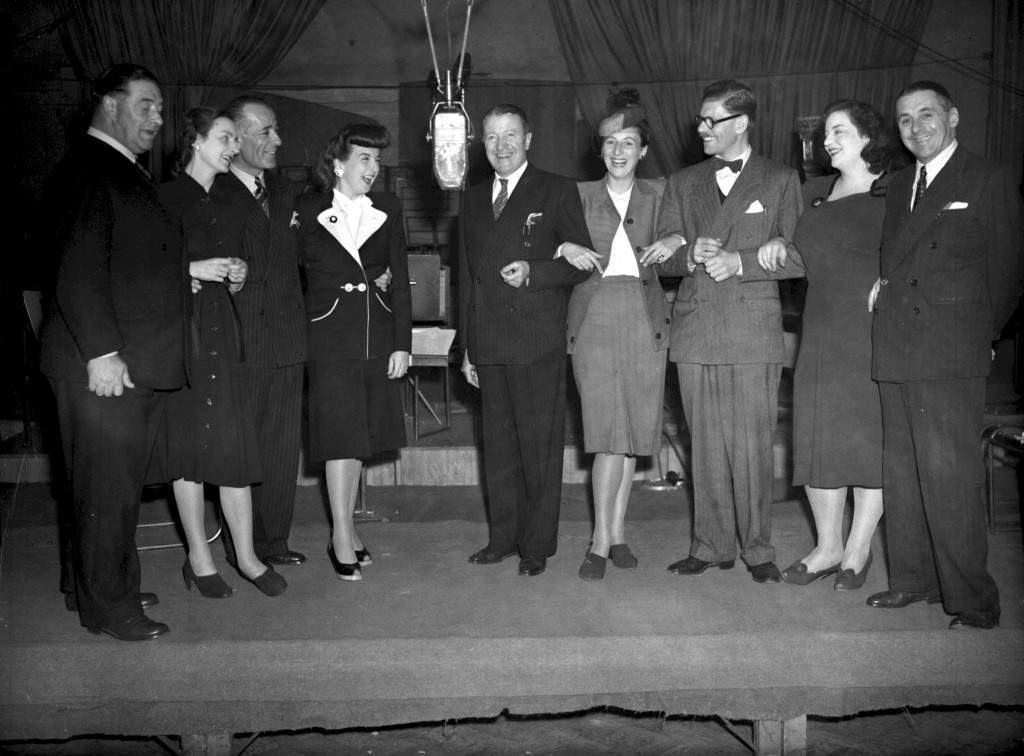 From left to right: Fred Yule, Joan Harben, Hugh Morton, Lind Joyce, Tommy Handley, Diana Morrison, Derek Gyler, Hattie Jackes and Jack Train during rehearsals for the radio show “ITMA” in London.