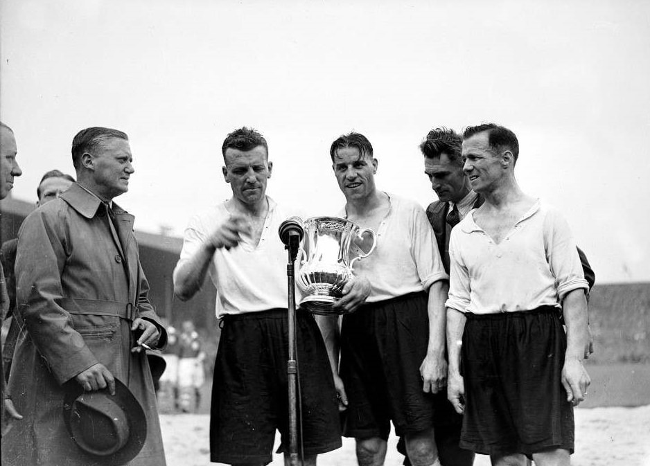 Derby County captain 36 year old Jack Nicholas (second left) steps up to the microphone with the FA Cup to give his opinion on his team’s extra time 4-1 victory, 1946.