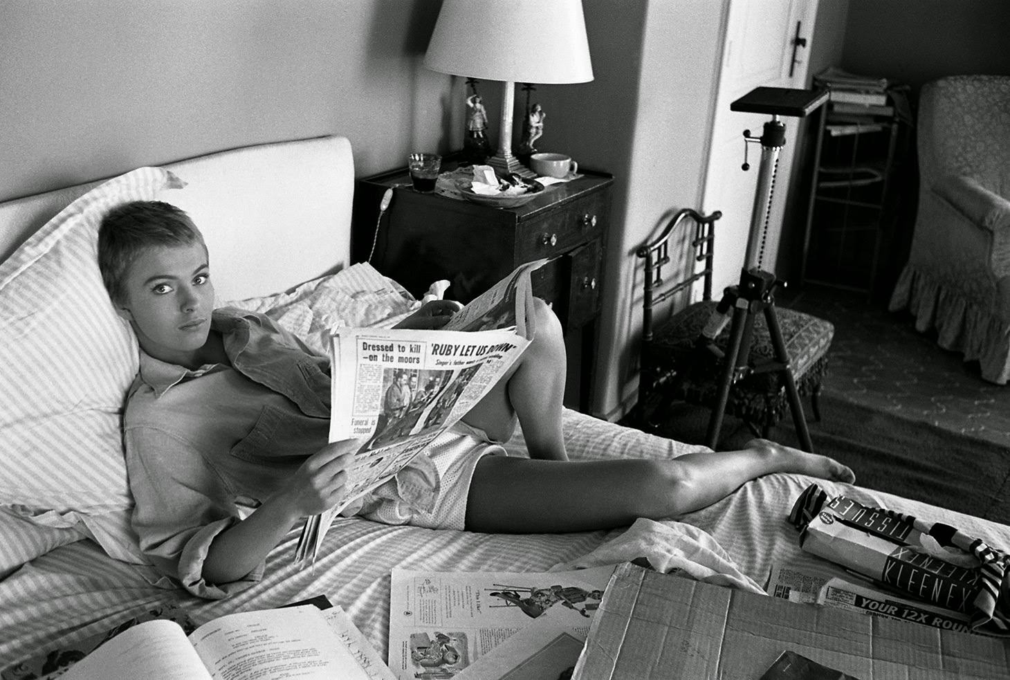 Jean Seberg reads the paper in bed during filming of "Bonjour Tristesse" in France, 1957