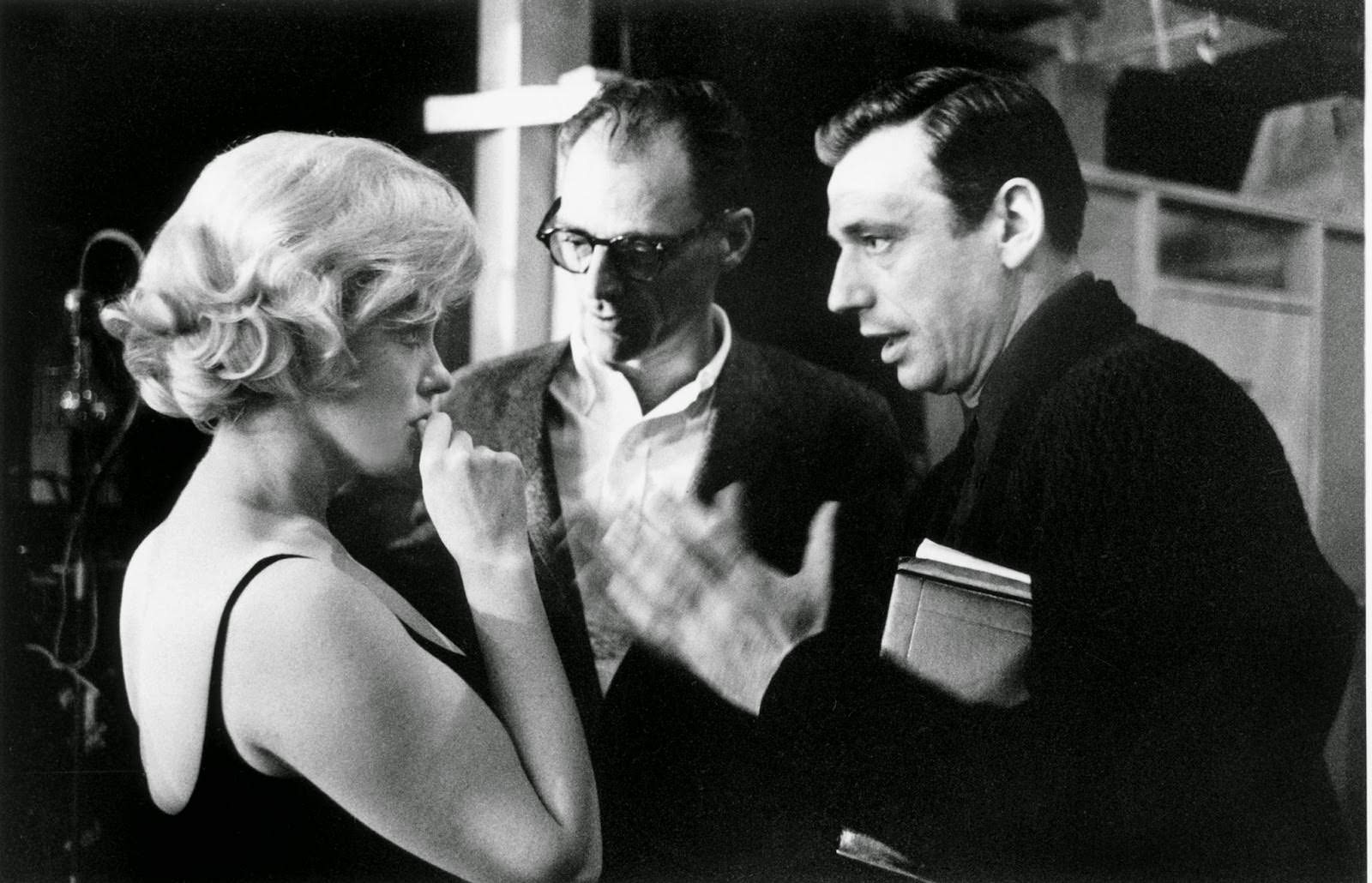 Marilyn Monroe digests what is proposed on set of "Let's Make Love" with Yves Montand and husband Arthur Miller, 1960