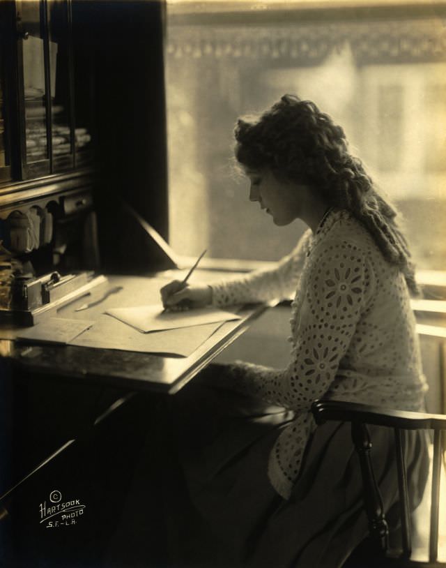 Mary Pickford writing at a desk, 1918