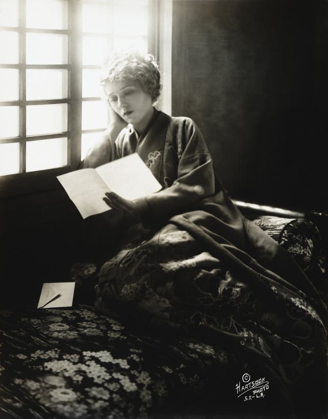 Mary Pickford, wearing a kimono, reading a letter, 1918