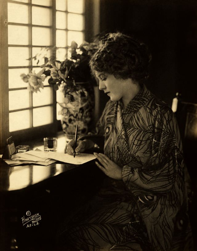 Mary Pickford, wearing a kimono, writing at a desk, 1918