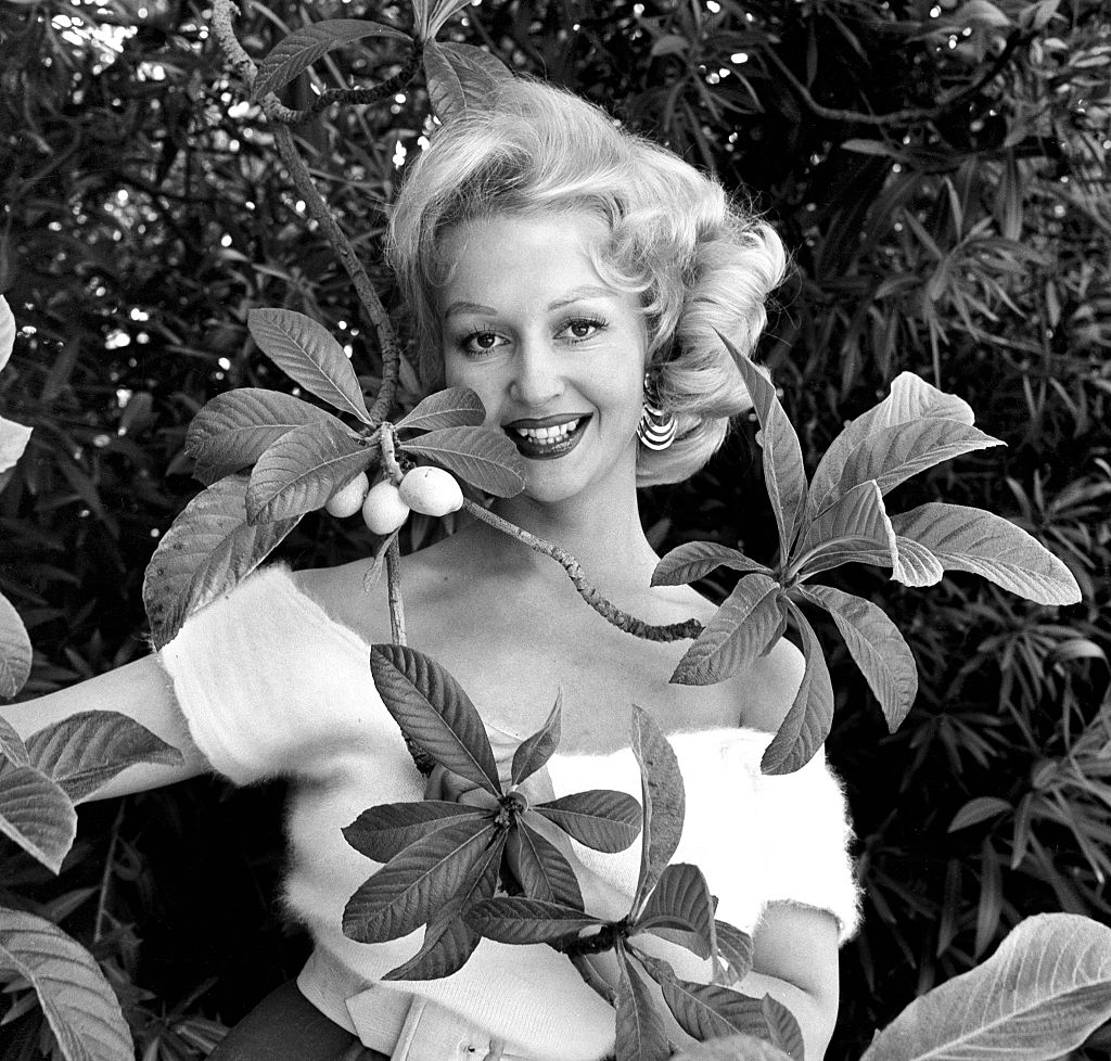 Greta Thyssen posing behind the tree, 1956.