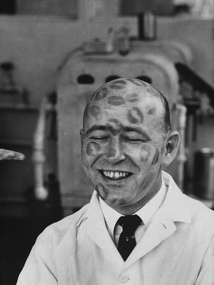 Worker in cosmetic company covered with relics of lipstick kisses to prove that dyes in lipsticks are harmless, 1960