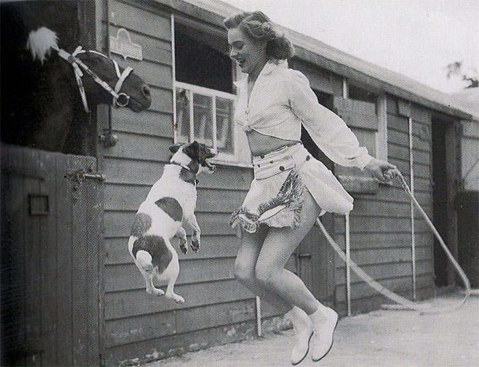 Woman and dog jumping rope, 1940s
