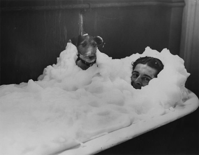 Wally kilminster enjoys a foam bath with his dog in the dressing rooms at wembley stadium, 1934