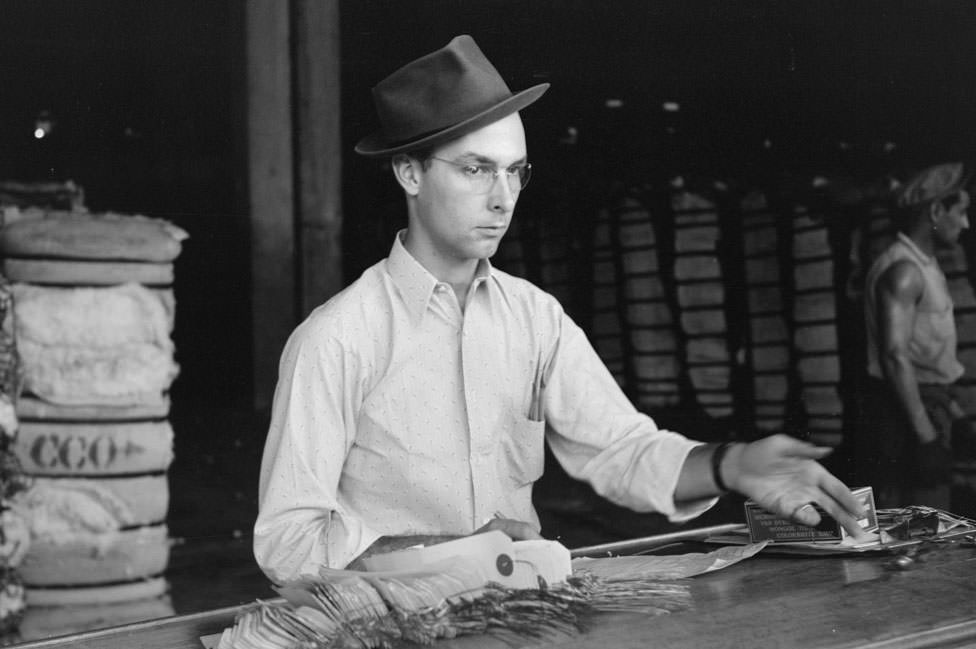 Weighing checker at unloading platform. Cotton compress, Houston, 1930s