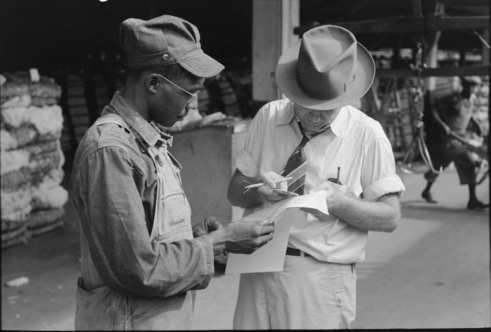 Trucker and weighing checker at unloading platform. Cotton compress, Houston, Texas