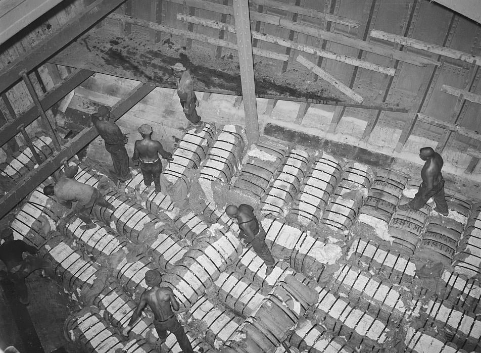 Storing bales of cotton into hold for freighter for export. Port of Houston, Texas