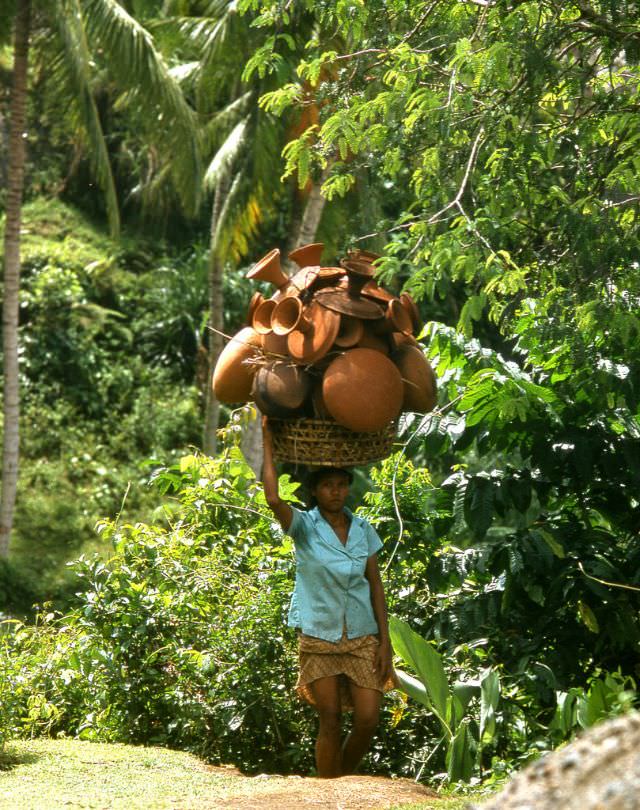 Balinese woman on her way to market with a large load of pottery, 1970s