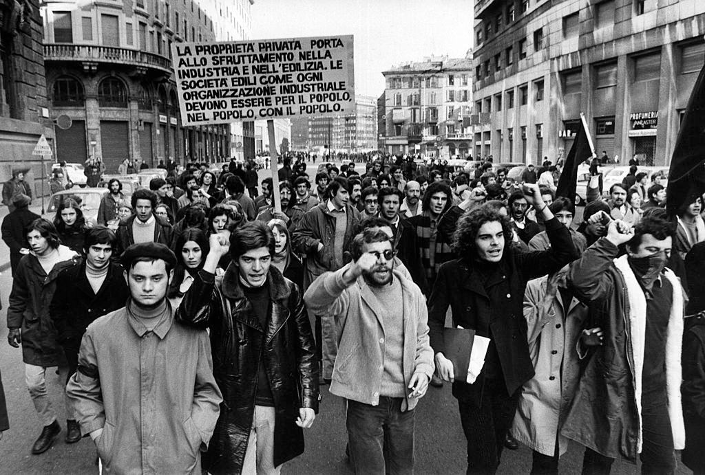 Group of anarchists with black flags demonstrating in Corso Europa, Milan, 1960s.