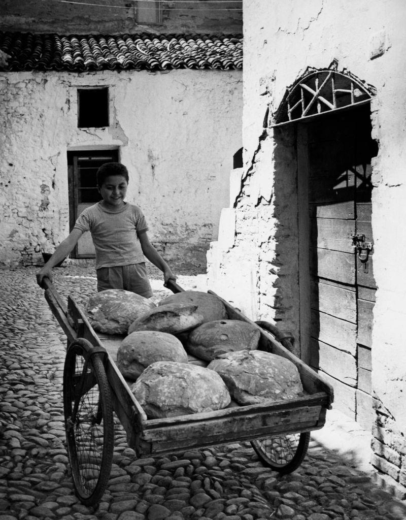 A child carrying the bread in Basilicata, Italy, 1960.