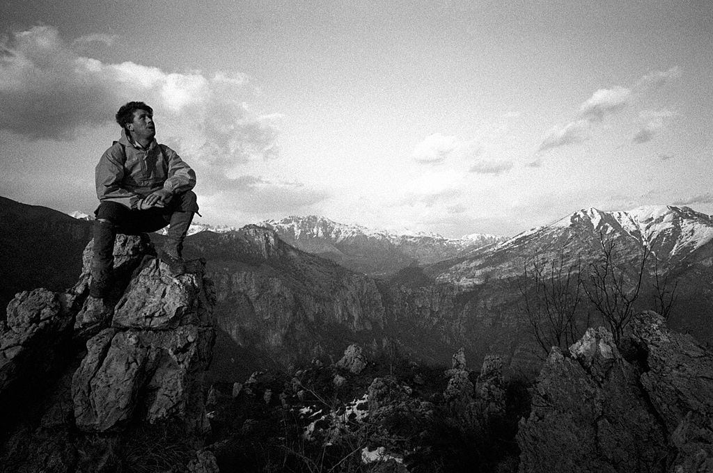 Italian climber and explorer Carlo Mauri sitting on top of a mountain, 1960s.