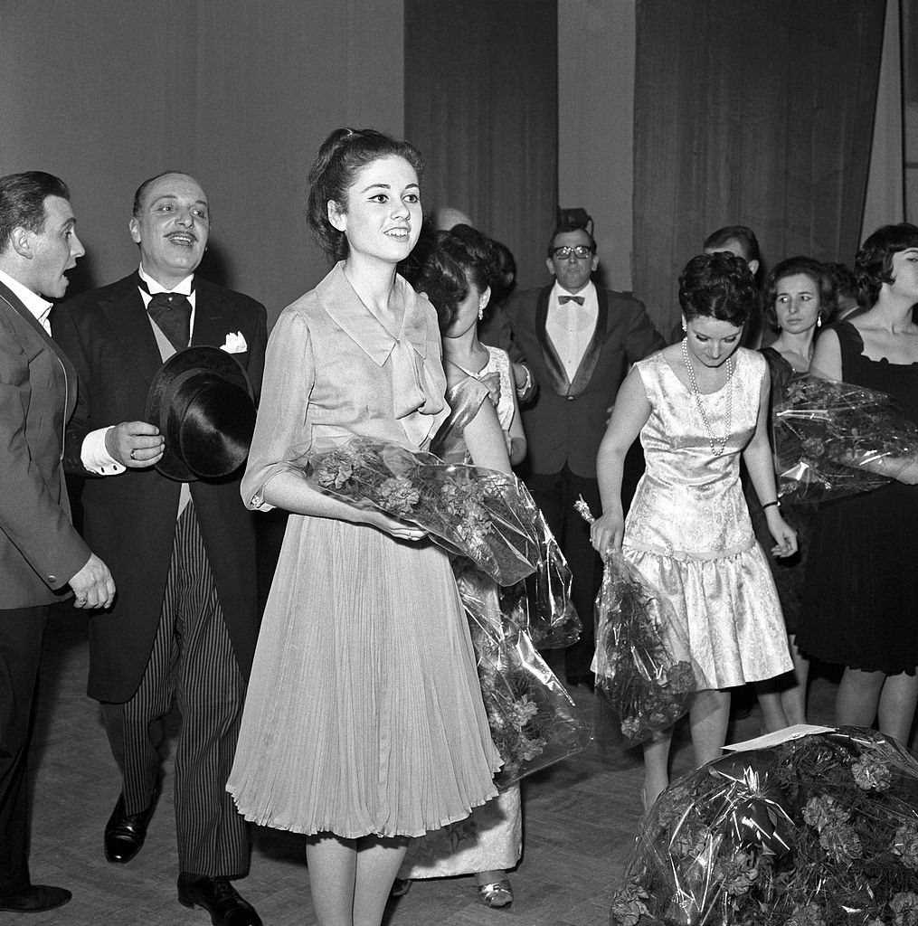 Italian singer, actress and TV presenter Gigliola Cinquetti holding a bunch of flowers in her hands, 1960s.