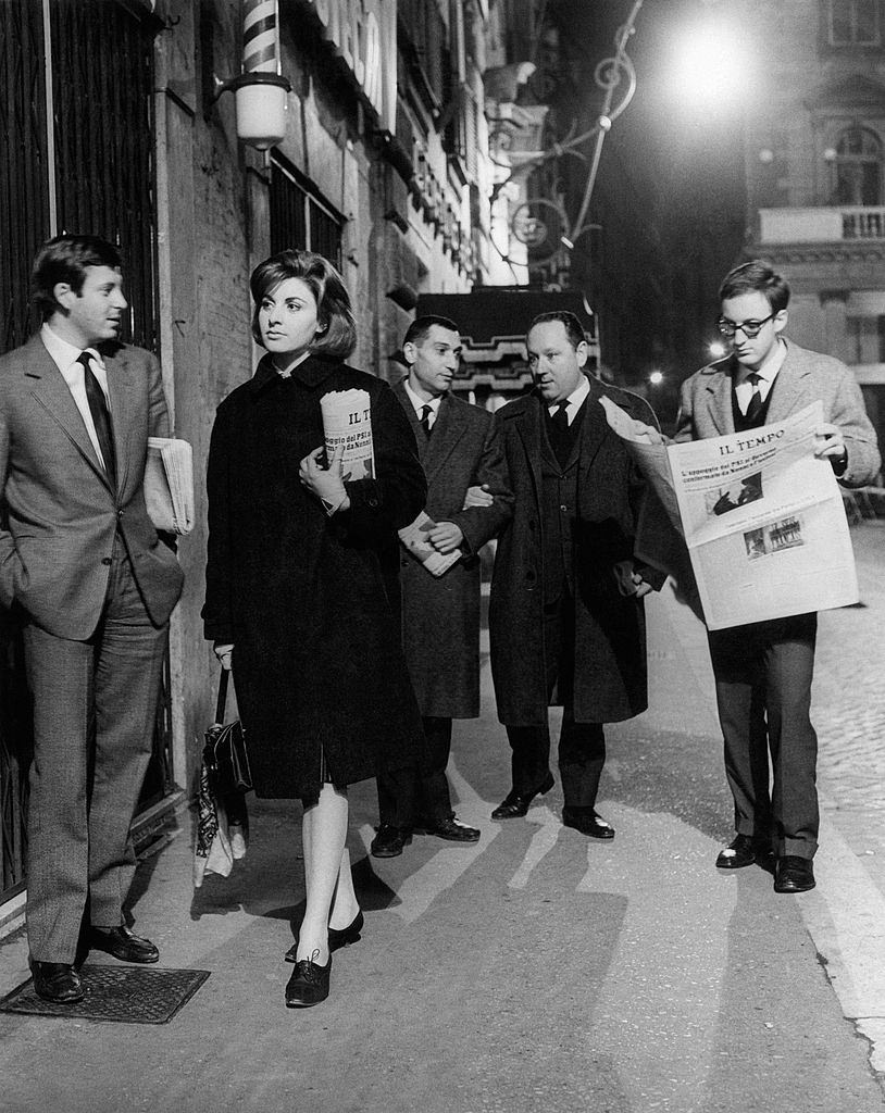 Some young journalist coming back home holding the fresh copies of the newspaper Il Tempo. Rome, 1960s.