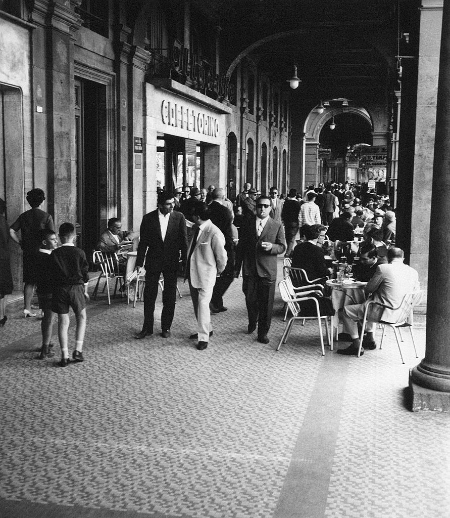 Many people crowding the arcades of via Roma, 1960s.