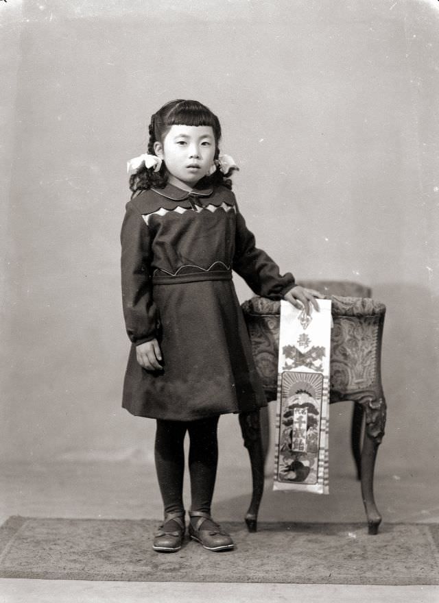 A girl in braids, a dress, and flats holding Chitose Ame Shichi-Go-San candy